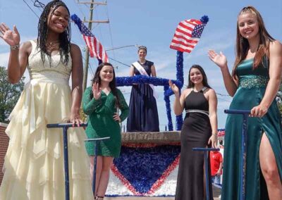 Apple Ambassadors waving from their King Apple Parade float at the Apple Festival.