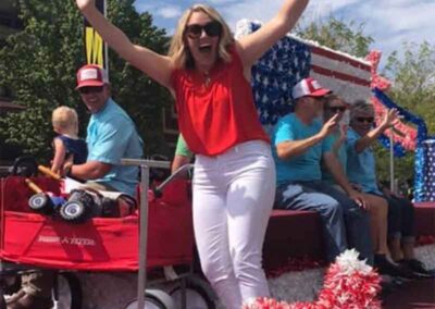 Happy woman, waving from an Apple Festival parade float